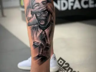 tatuaj cu masca pe picior barbat