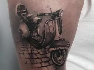 tatuaj cu scuter pe brat barbat