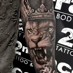 Tatuaj antebrat barbat leu cu coroana