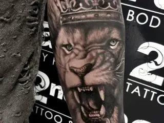 Tatuaj antebrat barbat leu cu coroana